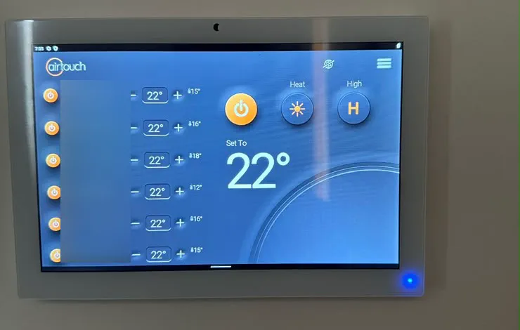 AirTouch touchscreen zone controller set to heat at 22 degrees, with the zone names blurred