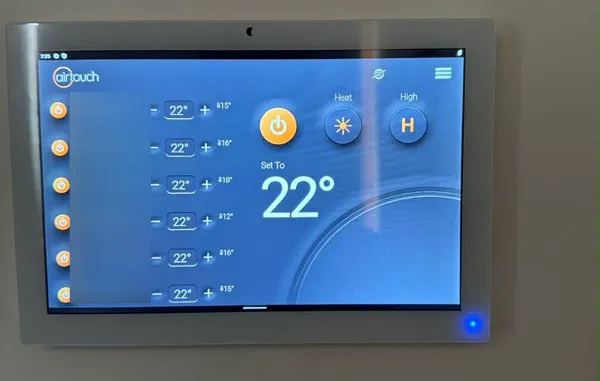 AirTouch touchscreen zone controller set to heat at 22 degrees, with the zone names blurred
