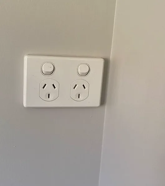 White double power point with switches, beside an internal wall corner