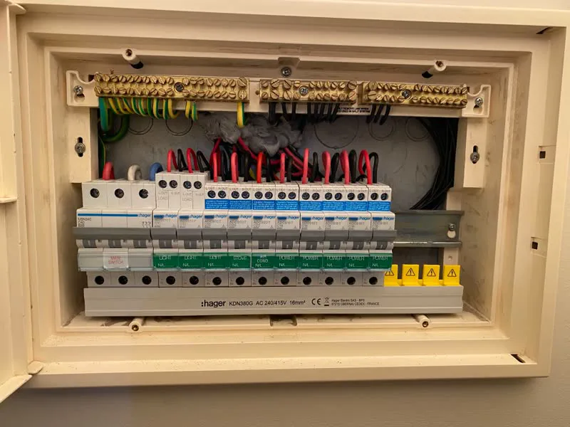 Flush-mounted Hager switchboard with a main switch, RCBOs and labels for the light, oven, cooktop and power circuits