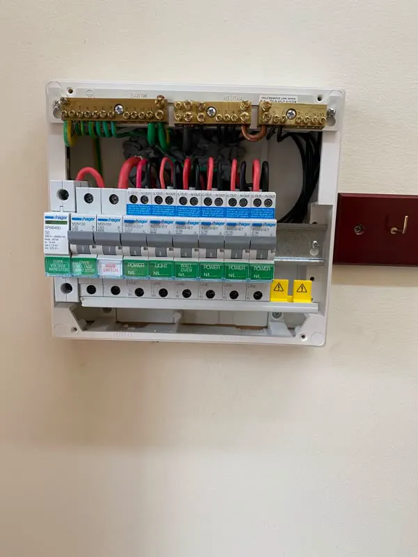 Hager switchboard on a white wall with a surge protection device, RCBOs and printed circuit labels