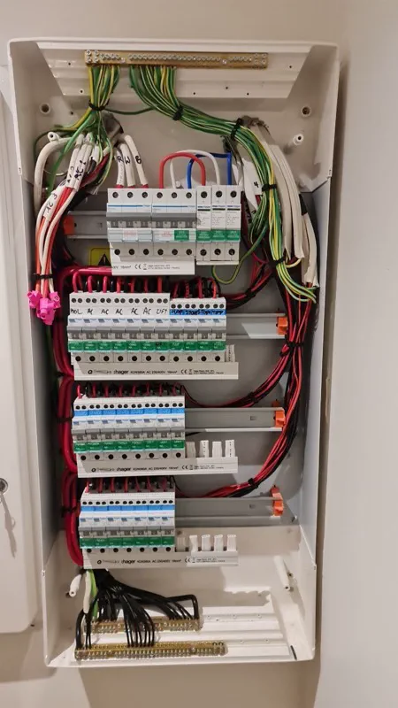 Large Hager switchboard with the cover off, showing rows of RCBOs on comb busbars and neatly looped cables