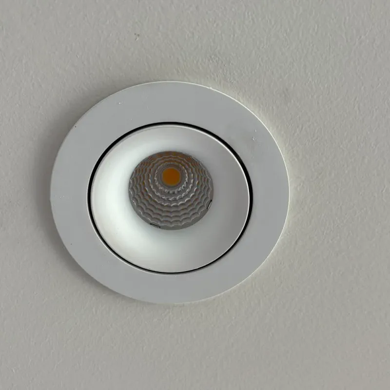Close-up of a white recessed LED downlight with an adjustable inner ring