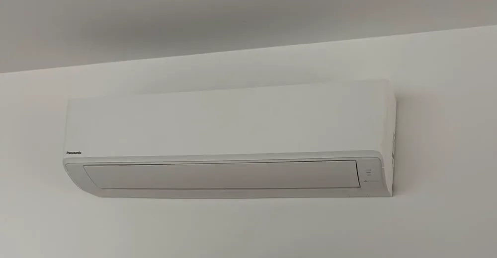 Panasonic wall-mounted split system high on a white wall