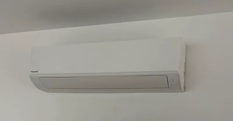 Panasonic wall-mounted split system high on a white wall