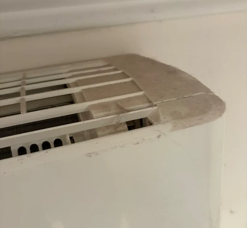 Dust and lint built up on the intake grille of a wall split