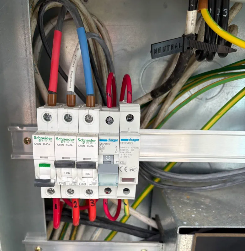 Hager surge protection device on a DIN rail beside circuit breakers inside a metal enclosure