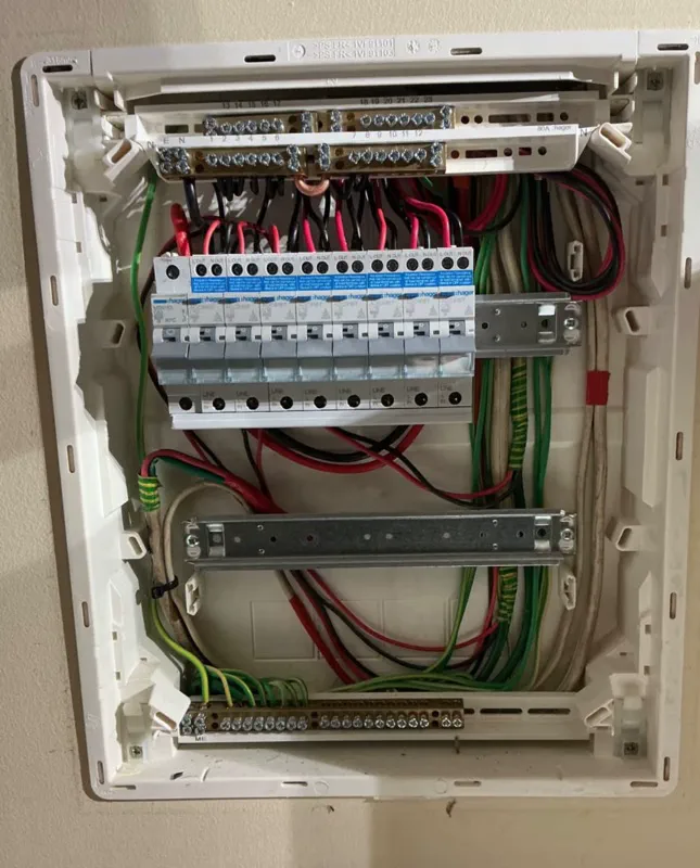 Hager switchboard with the cover off, showing a main switch and nine RCBOs