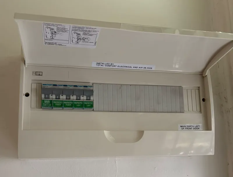 Finished HPM switchboard with a Hager main switch and four RCBOs, labelled installed by Total Comfort Electrical and Air 08.2026