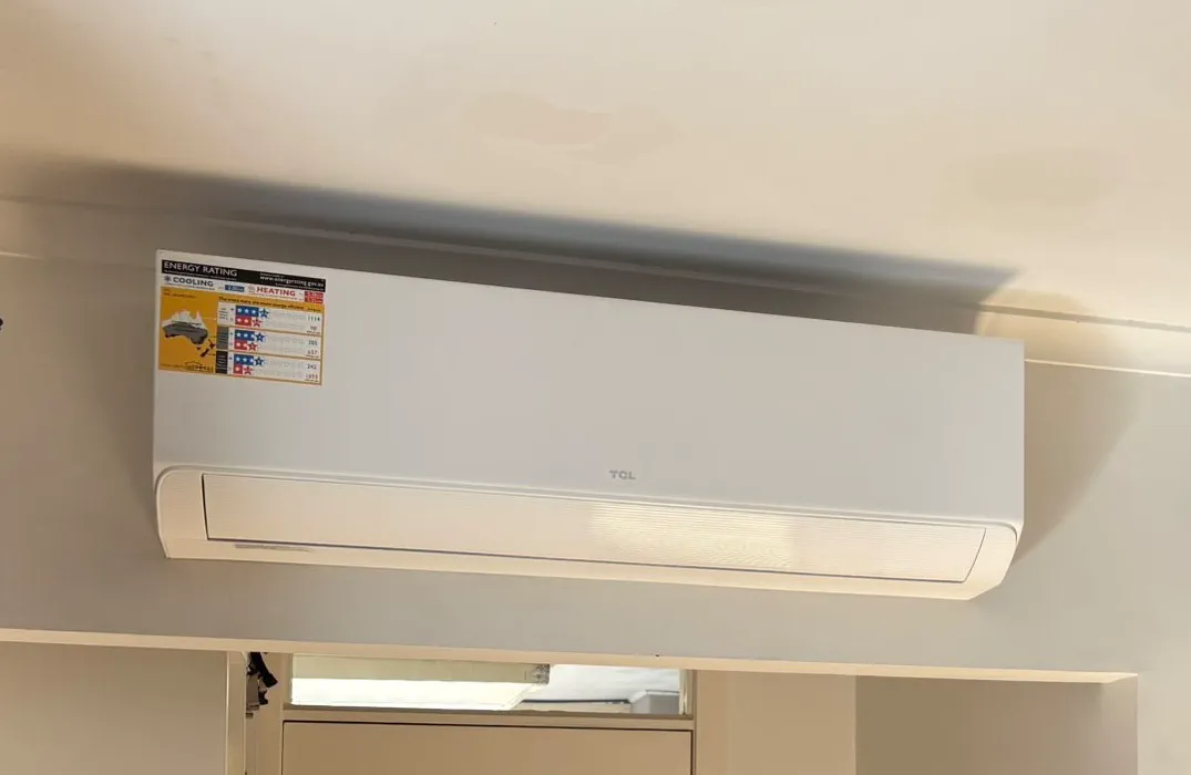 TCL wall-mounted split system with its energy rating label, mounted above a doorway