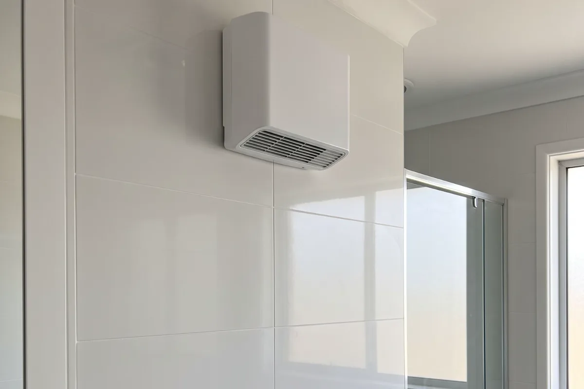 A wall-mounted fan heater and heated towel rail in a modern bathroom