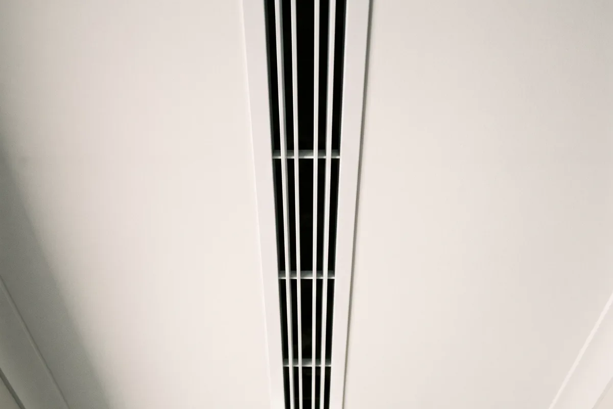 An air conditioning vent grille in a ceiling