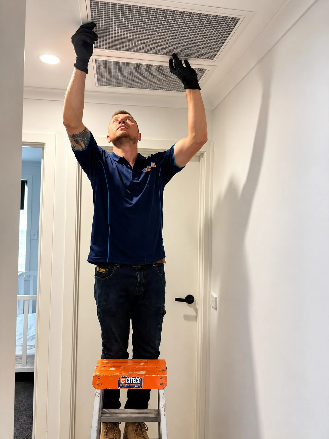 Total Comfort technician checking a ceiling return-air grille